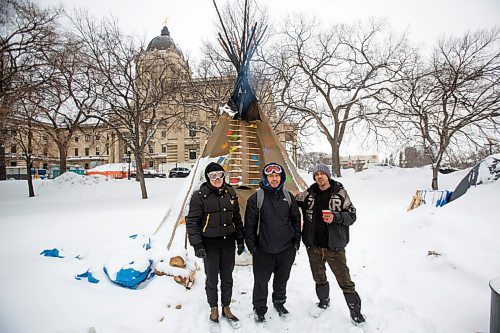 MIKE DEAL / WINNIPEG FREE PRESS
Volunteer Fire Keepers, Holly Enns (left) with her partner Daniel Kuya Caneda (centre), with full-time Fire Keeper, John Butler (right) outside the small tipi where the sacred fire has been burning on the grounds of the Manitoba Legislative building. 
See Melissa Martin story
220210 - Thursday, February 10, 2022.