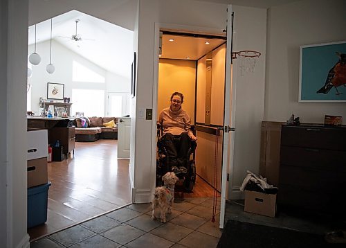 JESSICA LEE / WINNIPEG FREE PRESS

Yvette Cenerini, a digital collage maker and a wheelchair user, is photographed using the elevator at her home on February 15, 2022 while her dog Jasper greets her.

Reporter: Eva
