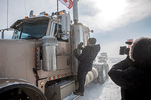 MIKE DEAL / WINNIPEG FREE PRESS
A reporter tries to talk to a trucker blocking the border crossing at Emerson, MB.
220216 - Wednesday, February 16, 2022.