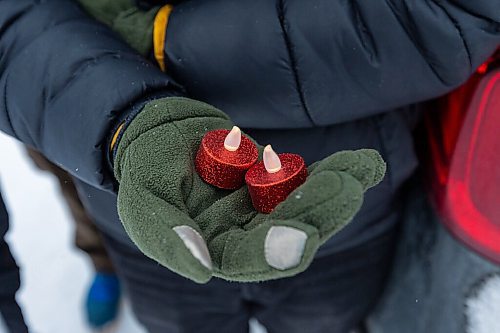 Daniel Crump / Winnipeg Free Press. A friends of John Lloyd Barrion holds electric candles during a vigil in his honour. The 19-year-old was killed while working at the beer vendor attached to the Travelodge on Notre Dame Ave. February 19, 2022.