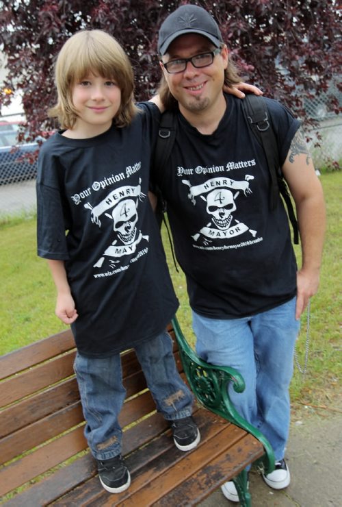 Brandon Sun Henry Hansen and his son Sebastian show the T-shirts he's had produced to help fund and promote his mayoral run in municipal elections this October. (Colin Corneau/Brandon Sun)