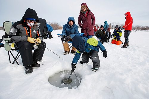 JOHN WOODS / WINNIPEG FREE PRESS
Liam, 6, cleans out a fishing hole as, from left, Emily MacDonald, and his father and mother, Max Kreuser and Micheline Marchildon, and other family and friends enjoy a day of fishing at Lockport, Sunday, February 20, 2022. There is a licence free Winter Family Fishing Weekend happening this weekend. Emily MacDonald has been coming ice fishing with her parents since she was a baby.

Re: standup
