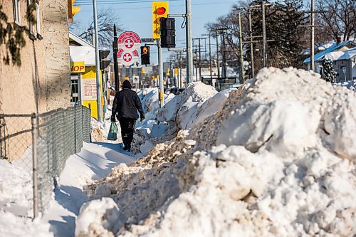 MIKAELA MACKENZIE / WINNIPEG FREE PRESS

Pedestrians struggle to navigate the almost non-existent sidewalk, which has been taken over by snowbanks, on Saint Matthews Avenue in Winnipeg on Tuesday, Feb. 22, 2022. For Malak story.
Winnipeg Free Press 2022.