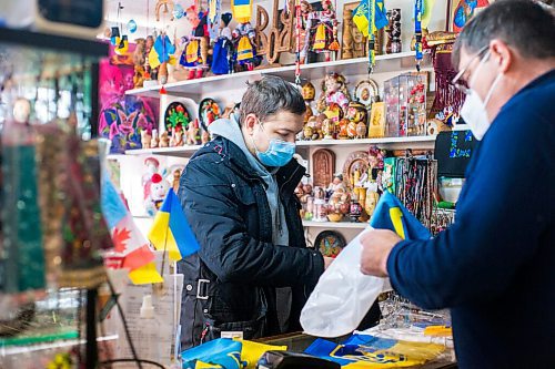 MIKAELA MACKENZIE / WINNIPEG FREE PRESS

Svitoch Ukrainian Export & Import owner Ruslan Zeleniuk (right) packs up flags for Alexey, who has family in the Luhansk region, in Winnipeg on Thursday, Feb. 24, 2022. For Erik story.
Winnipeg Free Press 2022.