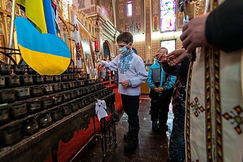 Daniel Crump / Winnipeg Free Press. Kids say prayers for Ukraine and light candles at the Ukrainian Catholic Metropolitan Cathedral of Sts. Volodymyr and Olha. March 5, 2022.