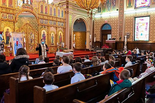 Daniel Crump / Winnipeg Free Press. Reverend Ihor Shved leads a group of kids in prayer at the Ukrainian Catholic Metropolitan Cathedral of Sts. Volodymyr and Olha. March 5, 2022.