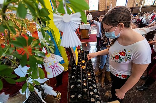 Daniel Crump / Winnipeg Free Press. Kids say prayers for Ukraine and light candles at the Ukrainian Catholic Metropolitan Cathedral of Sts. Volodymyr and Olha. March 5, 2022.