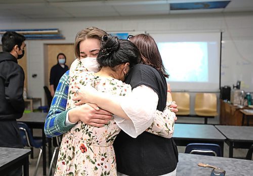 RUTH BONNEVILLE / WINNIPEG FREE PRESS

Local - Fort Richmond helps dad in Ukraine

Karen Robb (EA at Fort Richmond Collegiate, shares a hug with her students in her class.  Moments earlier the was shocked when she got an unexpectant call from her birth father, Gary Milani Wednesday, after he arrived safely in Krakow Poland with the help of her students. Robb was with her grade 12 Fort Richmond Collegiate students getting a photo for the Free Press when the call came in Wednesday afternoon.  

The media were interviewing her and her students because her birth father was provided and escape route and a map from FRC students on the safest way to escape the Ukraine and get to Poland (map is on the overhead wall behind them).  

See story by Maggie Macintosh

Names:
Karen Robb (EA)
Adil Hayat (Male in middle)
Divya Sharma (FEMALE FLORAL SHIRT)
Kateryna Ivanets (Plaid shirt, G12)

March 9th,  2022
