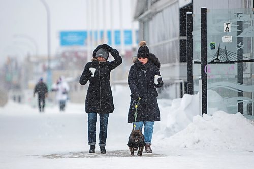 Daniel Crump / Winnipeg Free Press. People walk across the Esplanade Riel as heavy snow begins to fall Saturday afternoon. March 12, 2022.