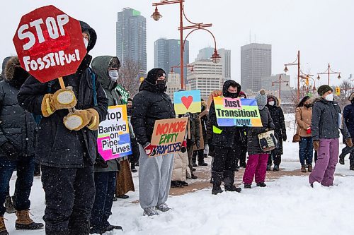 Daniel Crump / Winnipeg Free Press. People hold signs during a climate rally organized by Manitoba Energy Justice Coalition. Around 50 people attended the rally in front of the Canadian Museum for Human Rights at noon on Saturday. March 12, 2022.