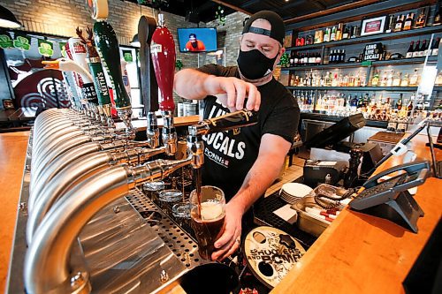 JOHN WOODS / WINNIPEG FREE PRESS
Jay Gilgour, owner of Fionn MacCools Restaurant and Pub, pulls a pint of Guinness at the pub Monday, March 14, 2022. With COVID-19 restrictions relaxing Kilgour and his staff are getting ready for the first St. Patricks Day celebration on March 17 to take place in two years.