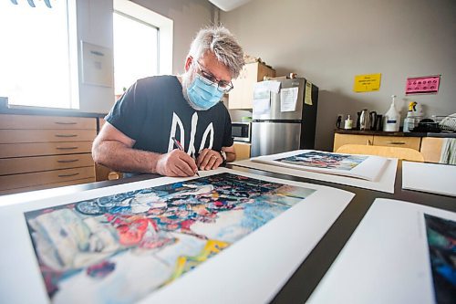 MIKAELA MACKENZIE / WINNIPEG FREE PRESS

Local artist Michael Boss, who is selling prints with proceeds going to the Ukrainian Red Cross, signs prints at the Martha Street Studio in Winnipeg on Friday, March 18, 2022.  For Alan Small story.
Winnipeg Free Press 2022.