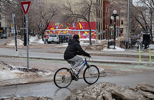JESSICA LEE / WINNIPEG FREE PRESS

A cyclist crosses a street amid melting snow in the Exchange District on March 21, 2022.


