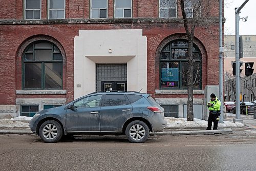 JESSICA LEE / WINNIPEG FREE PRESS

A parking enforcement officer checks if the parking meter was paid for a car in the Exchange District on March 21, 2022.


