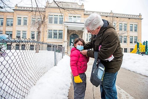MIKAELA MACKENZIE / WINNIPEG FREE PRESS

Robin Arnold puts a mask on his grandson Gabriel Reyes Arnold (six) while dropping him off after lunch at Luxton School, where a community case letter was recently sent out, in Winnipeg on Wednesday, March 23, 2022.  For Maggie story.
Winnipeg Free Press 2022.