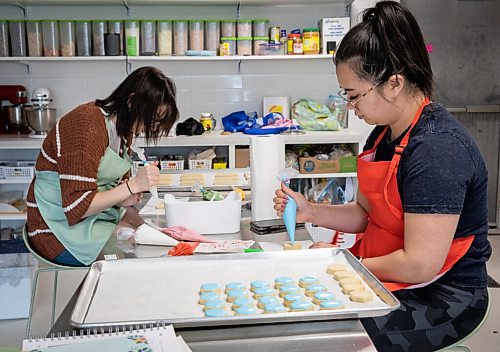 JESSICA LEE / WINNIPEG FREE PRESS

Shannon Pham (in red) and Jenna Bergstresser decorate cookies at Sugar Mama Cookie Co. on March 24, 2022. The store is having its soft launch on the 26th.

Reporter: Gabby