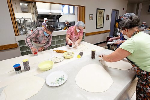 MIKE DEAL / WINNIPEG FREE PRESS
(from left) Cornelia Dombroski, Rosalie shupenia, and Jessie Sawicz cut the dough into discs with homemade stencils.
Holy Eucharist operates a year-round Perogy Hotline to raise funds for the church. Amid the crisis in Ukraine, the volunteers have started donating a portion of their proceeds to humanitarian efforts in the country.
see Eva Wasney story
220324 - Thursday, March 24, 2022.