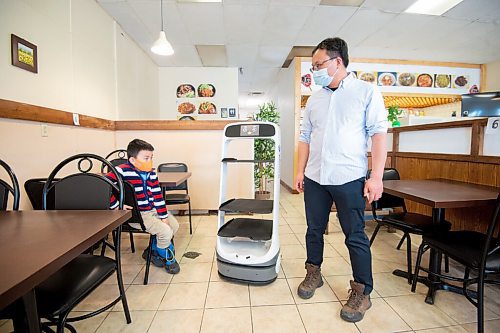 Mike Sudoma / Winnipeg Free Press
Hong Du Khae owner, Dirk Wang and his son Ricky Wang, watch as their newly hired robotic server makes its way to a table inside the restaurant Wednesday afternoon
March 30, 2022