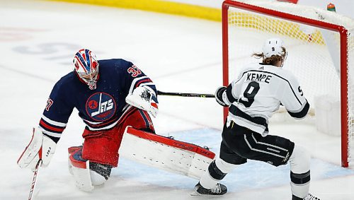 Los Angeles Kings' Adrian Kempe (9) scores on Winnipeg Jets goaltender Connor Hellebuyck (37) during first period NHL action in Winnipeg, Saturday, April 2, 2022. THE CANADIAN PRESS/John Woods