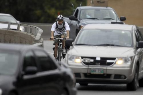 MIKE.DEAL@FREEPRESS.MB.CA 100810 - Tuesday, August 10, 2010 -  A cyclist crosses the Midtown Bridge on Smith Street wearing a helmet.  MIKE DEAL / WINNIPEG FREE PRESS