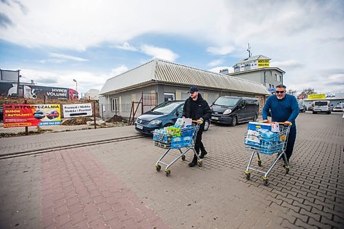 MIKAELA MACKENZIE / WINNIPEG FREE PRESS

Volunteers Bradley Taylor (left, from Britain) and Art Ballard (from California) push shopping carts full of items to drop off at the border, which will be taken into the Ukraine, in Medyka on Wednesday, April 6, 2022. For Melissa story.
Winnipeg Free Press 2022.