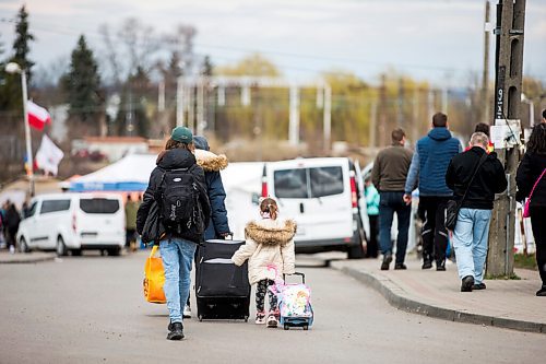 MIKAELA MACKENZIE / WINNIPEG FREE PRESS

Folks with suitcases and bags walk (likely gong back to the Ukraine) on the walkway to the border crossing after getting off of buses at Medyka on Wednesday, April 6, 2022. For Melissa story.
Winnipeg Free Press 2022.