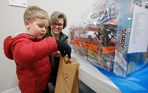 JOHN WOODS / WINNIPEG FREE PRESS
Anastasia Aslnova and her son Leo place silent auction tickets at the Easter Ukrainian Market at the Sts. Vladimir & Olga Cathedral Sunday, April 10, 2022. Proceeds will be donated to Help Ukraine