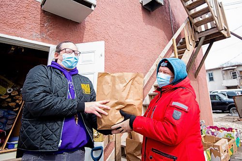 Mike Sudoma / Winnipeg Free Press
Sunshine House staff, Levi Foi (left) and Kelly Houle (right) share a moment while passing hampers to each other Tuesday evening
April 12, 2022