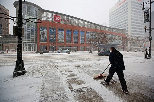 MIKE DEAL / WINNIPEG FREE PRESS
Thomas shovels the sidewalk in front of the Stantec office on Portage Avenue during the blizzard Wednesday morning. 
220413 - Wednesday, April 13, 2022