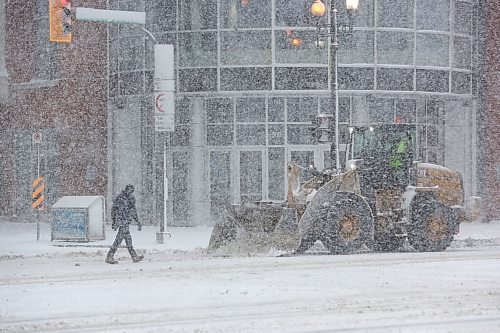 MIKE DEAL / WINNIPEG FREE PRESS
A pedestrian crosses Donald Street during heavy snowfall while front end loaders clear snow Wednesday morning. 
220413 - Wednesday, April 13, 2022.