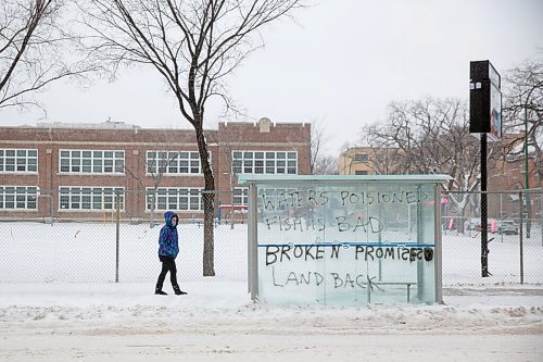 MIKE DEAL / WINNIPEG FREE PRESS
A person waits in a graffitied bus stop on Maryland Street, Thursday morning. 
220414 - Thursday, April 14, 2022.