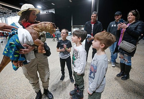 JOHN WOODS / WINNIPEG FREE PRESS
From left, Wyatt Mcleod, Mason and Jonah McDowell meet a baby dinosaur character as parents Cory Mcleod, Kevin McDowell and Lisa Mcleod look on during Jurassic Quest at the Convention Centre Friday, April 15, 2022. 

Re: searle