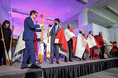 MIKE DEAL / WINNIPEG FREE PRESS
HBC Governor, Richard Baker, hands Prime Minister Trudeau a paddle as special guests receive commissioned blankets from SCO and paddles from HBC.
The Southern Chiefs Organization took possession of the downtown Winnipeg, Hudsons Bay Co. building during a two-hour ceremony Friday morning, which was attended by Prime Minister Trudeau, Manitoba Premier Heather Stefanson, Southern Chiefs Organization Grand Chief, Jerry Daniels, HBC Governor, Richard Baker, Ahmed Hussen, Minister of Housing and Diversity and Inclusion, Patty Hajdu, Minister of Indigenous Services Canada, and Dan Vandal, Minister of Northern Affairs and Minister responsible for Prairies Economic Development Canada. The vacant six-storey building, which opened in 1926 was closed in November 2020.
220422 - Friday, April 22, 2022.