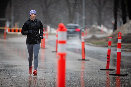 Daniel Crump / Winnipeg Free Press. A person runs on Wellington Crescent during heavy rain in Winnipeg on Saturday afternoon. Southern Manitoba can expect significant amounts of rain this weekend, likely totalling from 30 to 50mm. April 23, 2022.