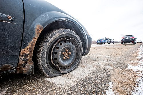 MIKAELA MACKENZIE / WINNIPEG FREE PRESS

A tow truck passes a car pulled over onto the shoulder with a flat tire and bent rim from bad potholes on Bishop Grandin Boulevard in Winnipeg on Monday, April 25, 2022. For --- story.
Winnipeg Free Press 2022.