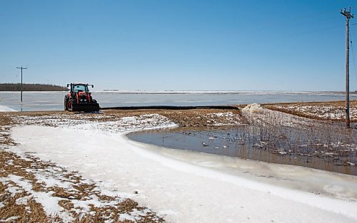 MIKE DEAL / WINNIPEG FREE PRESS
A tractor keeps a pump running as it moves water from a farmers field into Wavey Creek close to Sutherland Road and Highway 8, Tuesday afternoon.
220426 - Tuesday, April 26, 2022.