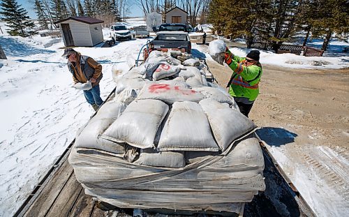 MIKE DEAL / WINNIPEG FREE PRESS
David Sutherland (yellow jacket) and his brother Ron (grey vest) unload sandbags with help from brother-in-law Garry Willis driving the Bobcat. They are concerned that overland flooding might flood Ron's house which is close to Sutherland Road and Highway 8, Tuesday afternoon.
220426 - Tuesday, April 26, 2022.