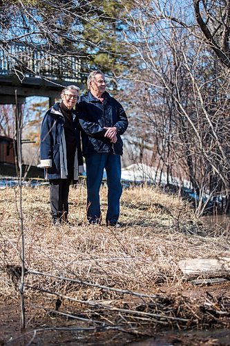 MIKAELA MACKENZIE / WINNIPEG FREE PRESS

Bob and Judy Roehle, St. Norbert homeowners who shared their memories of the 1997 flood, pose for a portrait by the river (and the house that nearly floated away) on their property on Tuesday, April 26, 2022.
Winnipeg Free Press 2022.
