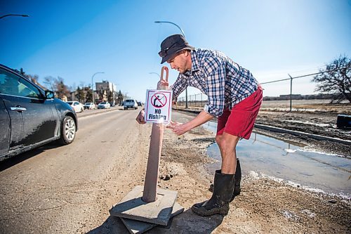 MIKAELA MACKENZIE / WINNIPEG FREE PRESS

Chris Thompson puts up a "no fishing" sign at a particularly large pothole on Route 90 in Winnipeg on Wednesday, April 27, 2022.
Winnipeg Free Press 2022.