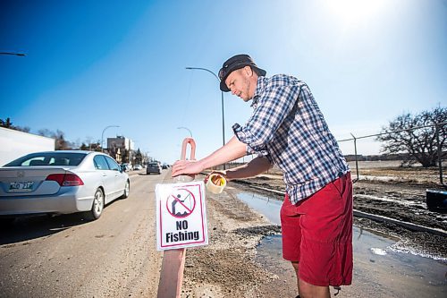 MIKAELA MACKENZIE / WINNIPEG FREE PRESS

Chris Thompson puts up a "no fishing" sign at a particularly large pothole on Route 90 in Winnipeg on Wednesday, April 27, 2022.
Winnipeg Free Press 2022.