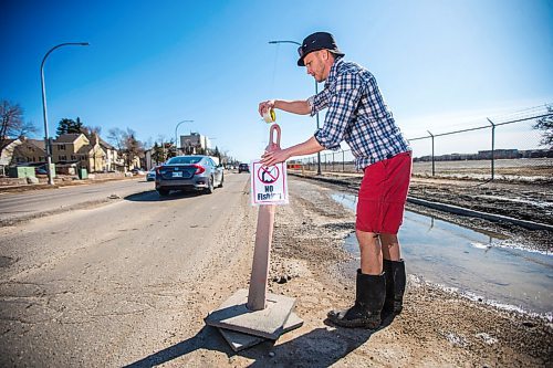 MIKAELA MACKENZIE / WINNIPEG FREE PRESS

Chris Thompson puts up a "no fishing" sign at a particularly large pothole on Route 90 in Winnipeg on Wednesday, April 27, 2022.
Winnipeg Free Press 2022.