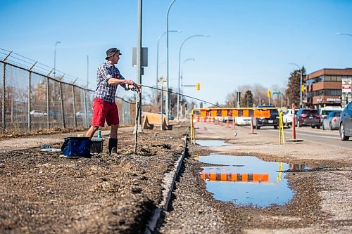 MIKAELA MACKENZIE / WINNIPEG FREE PRESS

Chris Thompson goes fishing at a particularly large pothole on Route 90 in Winnipeg on Wednesday, April 27, 2022.
Winnipeg Free Press 2022.