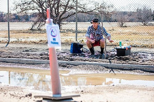 MIKAELA MACKENZIE / WINNIPEG FREE PRESS

Chris Thompson goes fishing at a particularly large pothole on Route 90 in Winnipeg on Wednesday, April 27, 2022.
Winnipeg Free Press 2022.