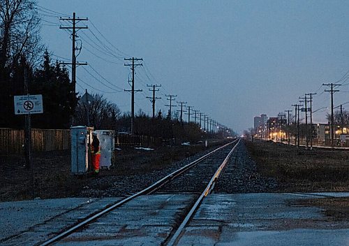 JESSICA LEE / WINNIPEG FREE PRESS

A worker looks in a cable box beside train tracks near Bairdmore Boulevard and Pembina on April 29, 2022. A collision between a train and car occurred there earlier that day. Two people were taken to the hospital.