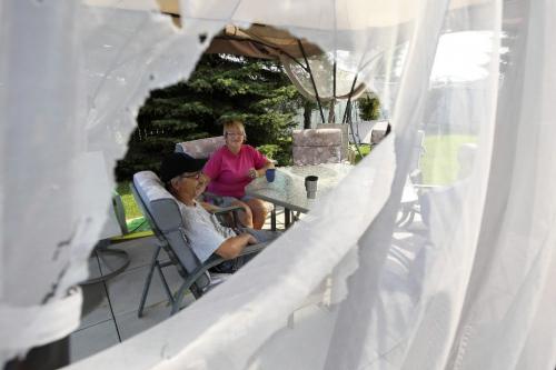 MIKE.DEAL@FREEPRESS.MB.CA 100821 - Saturday, August 21, 2010 -  Birdie and David Chuk sit under their destroyed canopy tent in the back yard of their home just south of the Perimeter on McPhillips the morning after a storm moved through with golfball sized hail. MIKE DEAL / WINNIPEG FREE PRESS