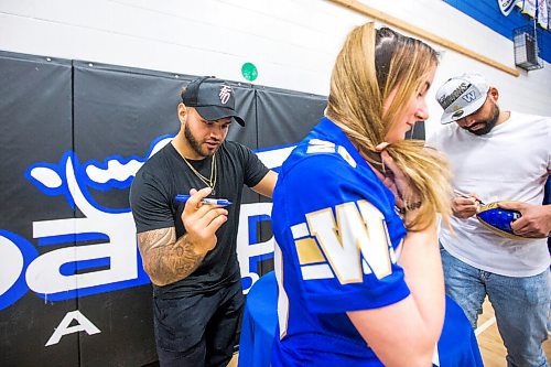 MIKAELA MACKENZIE / WINNIPEG FREE PRESS

Grade 12 student Alisha Mannette gets her jersey signed by Brady Olivera during a visit to Oak Park School with the Grey Cup in Winnipeg on Monday, May 2, 2022. For Taylor Allen story.
Winnipeg Free Press 2022.