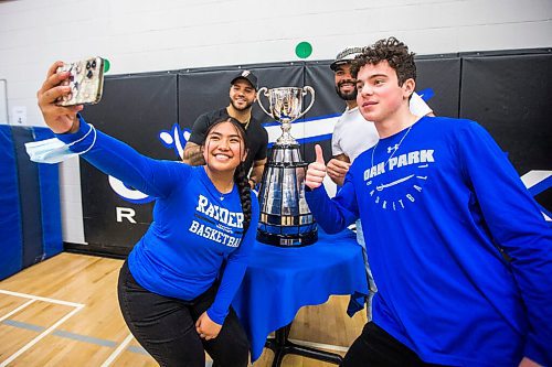 MIKAELA MACKENZIE / WINNIPEG FREE PRESS

Grade 12 students Kyla Marquez (left) and Ian Surasky pose for a selfie with Brady Olivera (centre left), Nic Demski, and the Grey Cup at Oak Park School in Winnipeg on Monday, May 2, 2022. For Taylor Allen story.
Winnipeg Free Press 2022.