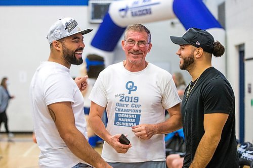 MIKAELA MACKENZIE / WINNIPEG FREE PRESS

Stu Nixon (retiring coach, centre) greets Nic Demski (left) and Brady Olivera during their visit to Oak Park School with the Grey Cup in Winnipeg on Monday, May 2, 2022. For Taylor Allen story.
Winnipeg Free Press 2022.