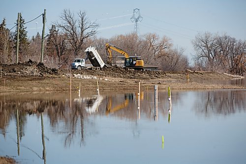 MIKE DEAL / WINNIPEG FREE PRESS
Crews work on building up the clay the dike that will be built across Red River Drive to help protect homeowners Tuesday morning.
220503 - Tuesday, May 03, 2022.