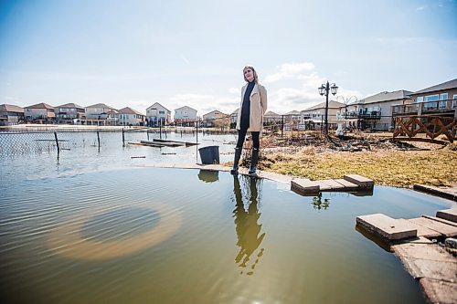 MIKAELA MACKENZIE / WINNIPEG FREE PRESS

Jennifer Lim poses for a portrait in her yard, which is partially flooded by an overflowing retention pond, in Winnipeg on Tuesday, May 3, 2022. For Chris Kitching story.
Winnipeg Free Press 2022.